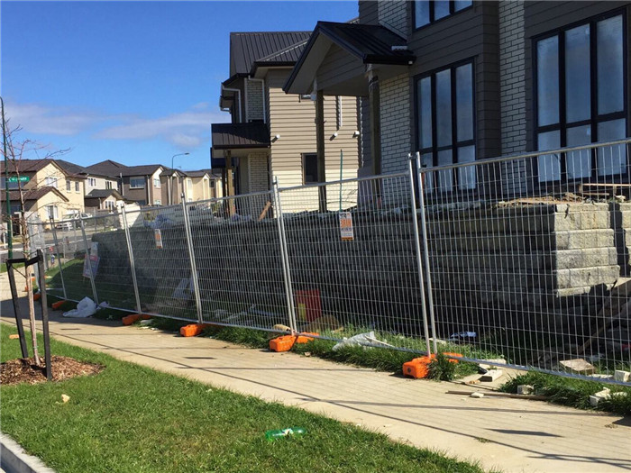 galvanized temporary fence panels with plastic feet and clamps installed on house site