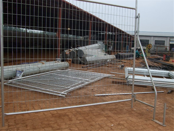 galvanized temporary fence panels with bracing and clamps installed on house site